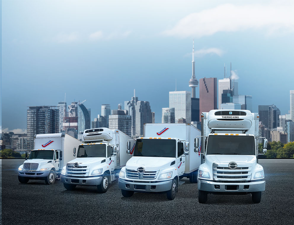 Concorde city truck, reefer, straight truck and second reefer in front of Toronto cityscape