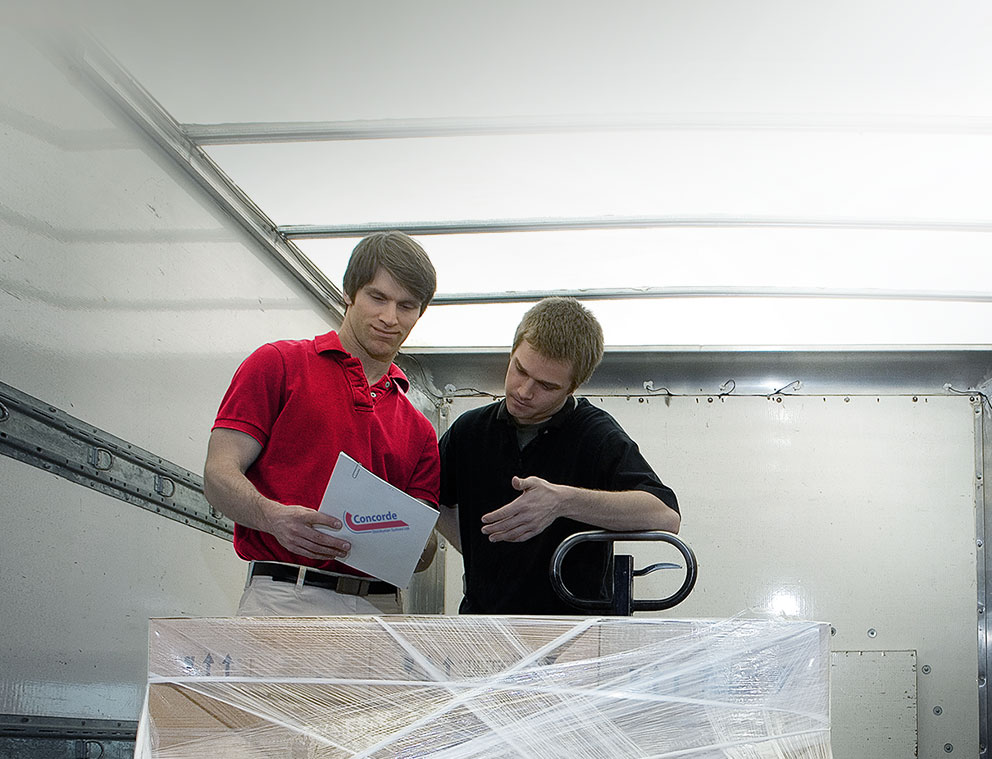 Concorde driver and staff inside trailer completing paperwork for pallet pickup