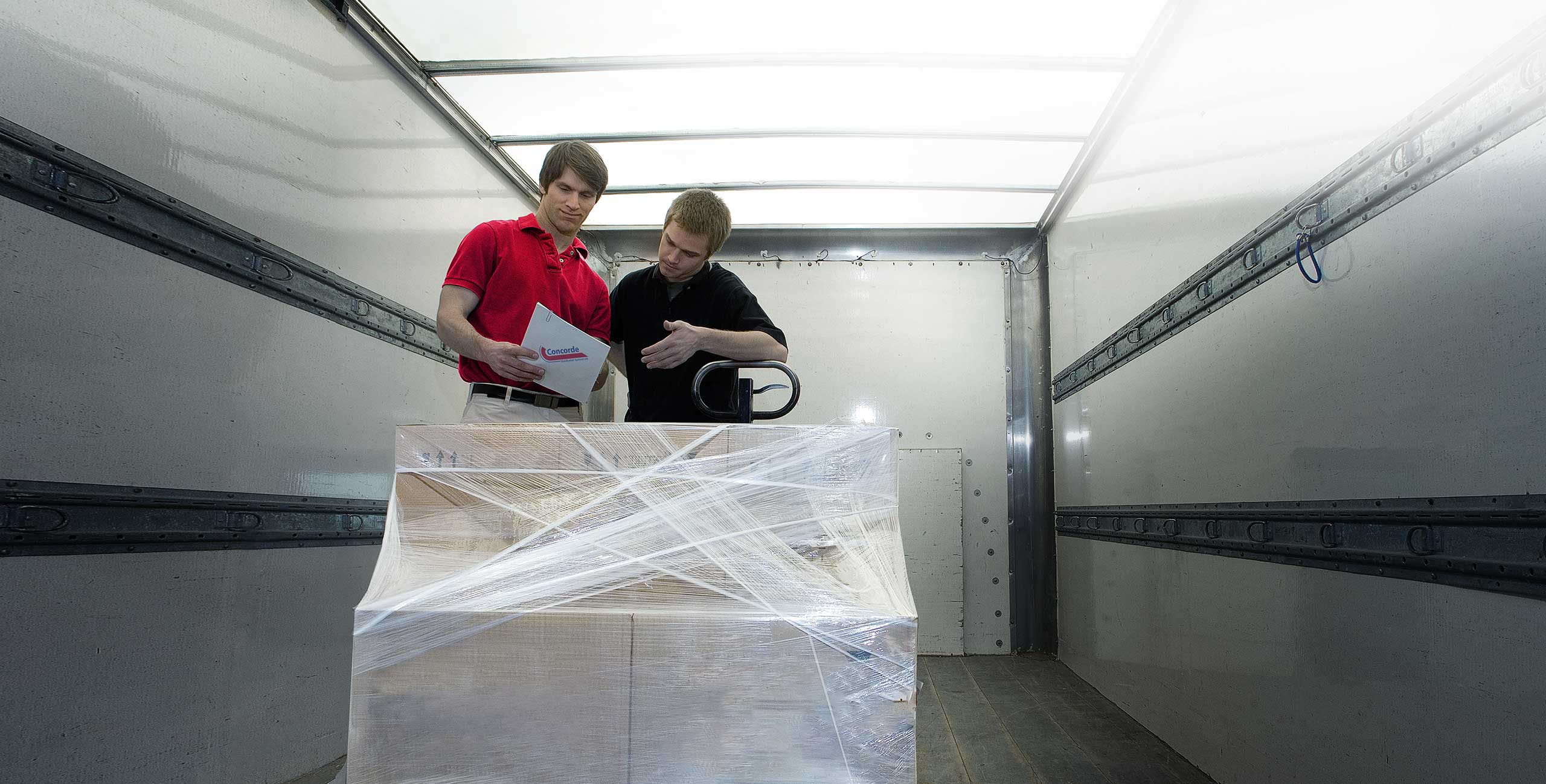 Concorde driver and staff inside trailer completing paperwork for pallet pickup