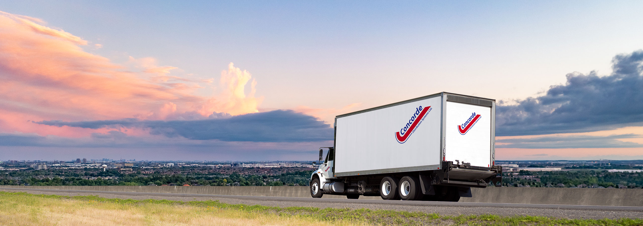 Concorde LTL straight truck driving on Ontario highway during sunset