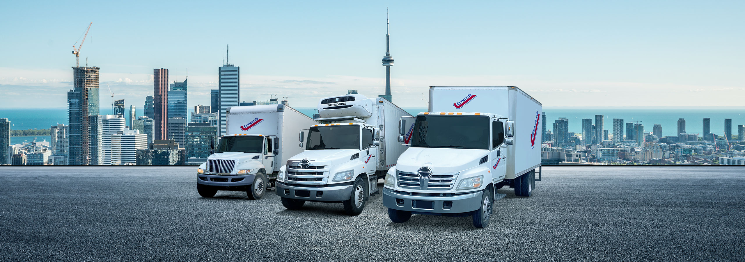 Concorde city truck, reefer and straight truck in front of Toronto cityscape